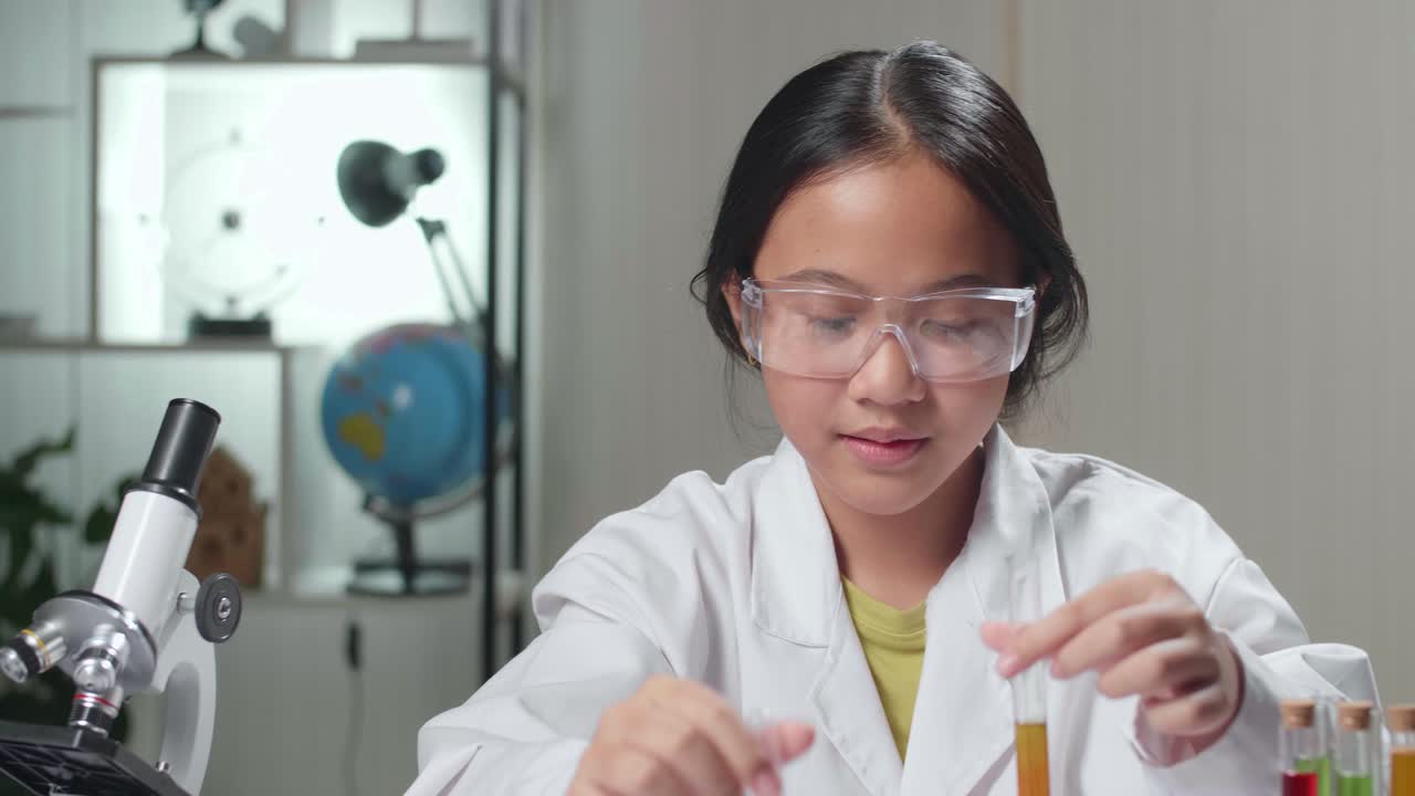 Young Asian Scientist Girl Mixes Chemicals In Test Tube. Child Learn With Interest