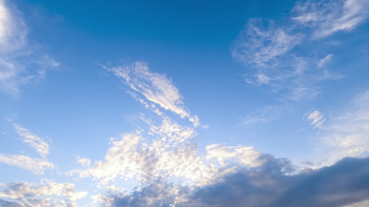 Light beautiful clouds flying along the blue sky. The skies cleaning from the cloudscape. Low angle view timelapse.