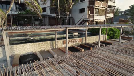 tulum, méxico: la vista rústica de la playa de amansala con tumbonas de madera y arquitectura