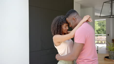 embracing and smiling, couple enjoying intimate moment together at home
