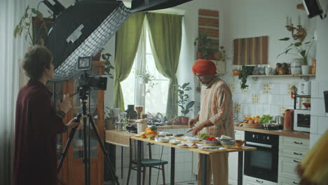 indian food blogger cooking in kitchen in front of camera