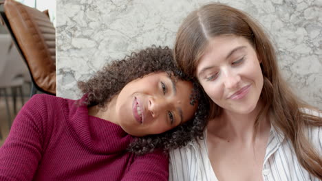 smiling and relaxing, lesbian couple enjoying quality time together at home
