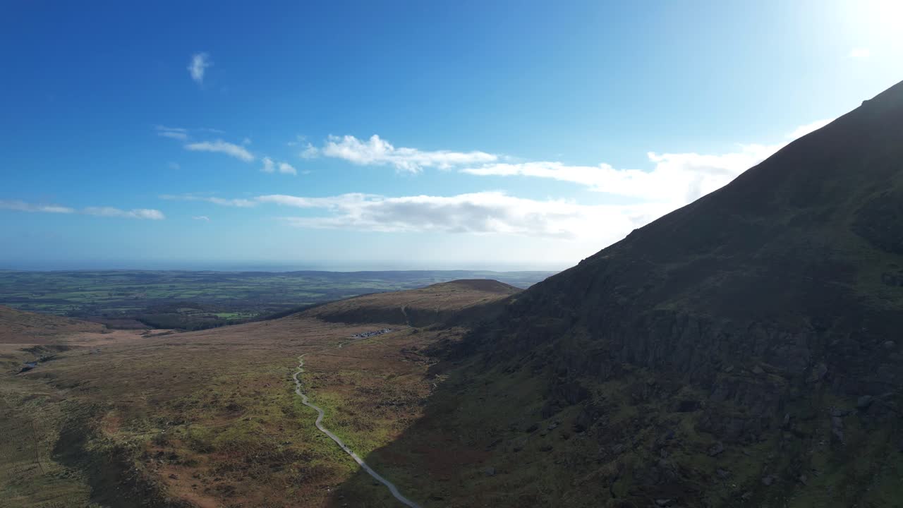 Drone flying in shadow of mountain to sea on horizon Comeragh Mountains Waterford Ireland