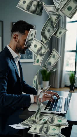 businessman working on laptop with money falling around