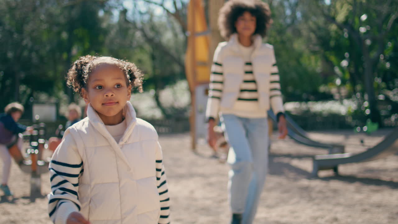 놀이터를 고 있는 아이, 걱정없는 주말을 즐기는 엄마, 가까이에서 걸어다니는 소녀