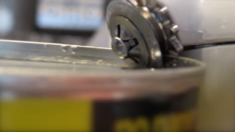 Opening a tin can with a can opener kitchen tool
