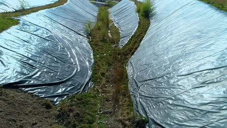 view from above of the sides of garbage dump hill covered with protective film