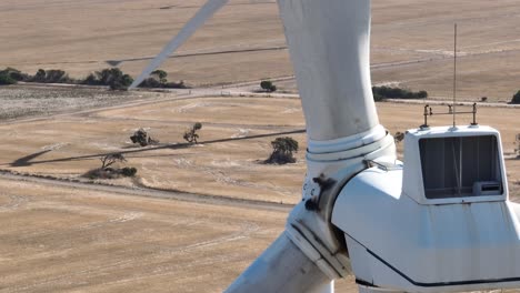 Drone-close-up-shot-of-Wind-Turbines,-shot-on-telephoto-lens-Drone-descending-to-reveal-a-seemingly-infinite-line-of-wind-turbines-spinning-in-the-distance-Shot-on-a-large-wind-farm-in-South-Australia