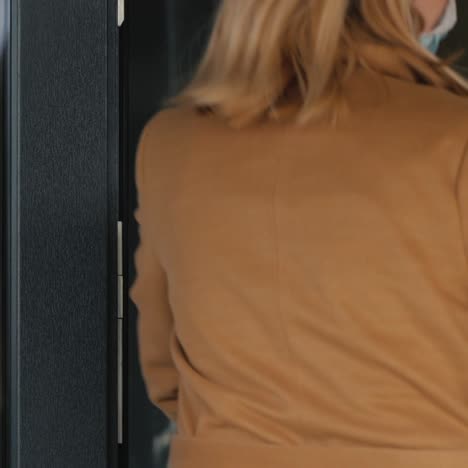 a woman with bags of food walks through the door of the house