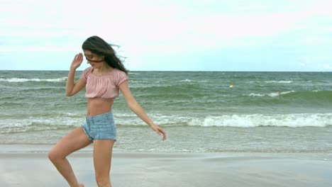 a beautiful young woman dressed casually and showing beautiful dance moves at the sea shore