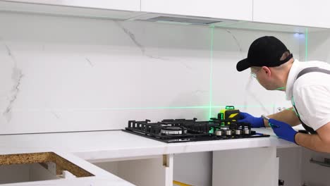 a worker installs a gas stove repair of the kitchen stove