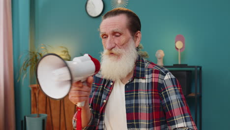 senior man talking with megaphone announcing news loudly announcing advertising in home office