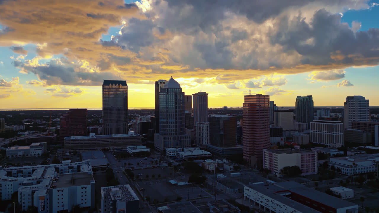 Tampa city skyline in early morning shadow, sunlight illuminating, tilt up from highway to building