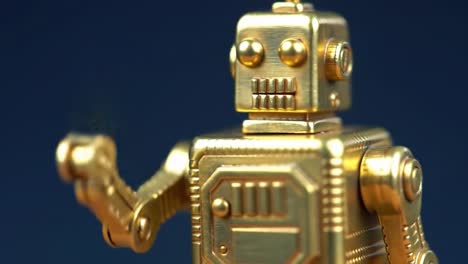 Golden Retro Robot Figure with Articulated Joints and a Friendly Gesture Captured in Two Stunning Frames of a Video Presentation