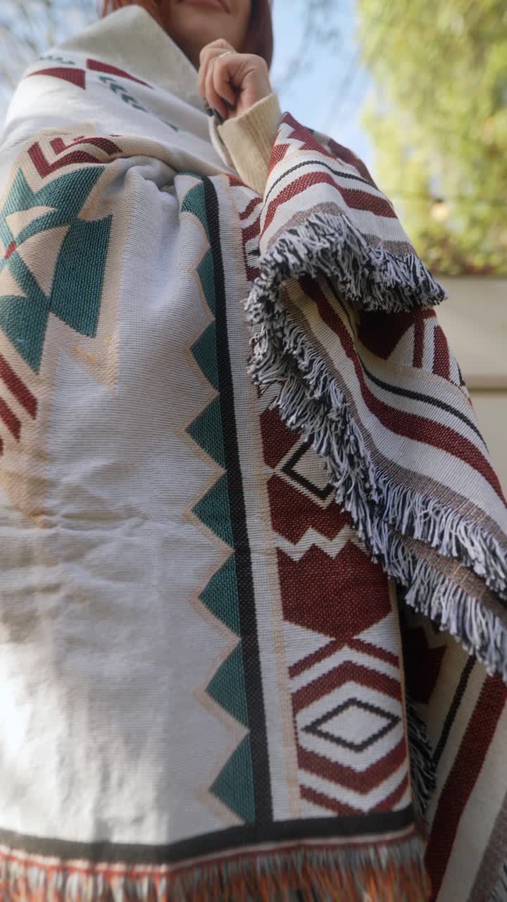 mujer con una manta acogedora al aire libre