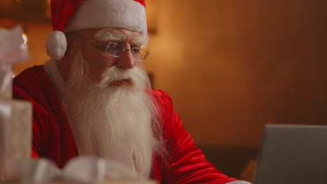 jolly santa working on a laptop computer. santa clause using laptop close-up. high quality 4k footage