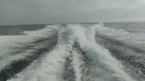 wake of water seen from behind of fast moving motor boat in a clear sky day,blue sea , water surface