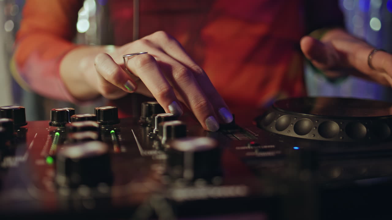 Disc jockey hands mixing music rhythm at nightclub closeup. Unknown woman Dj