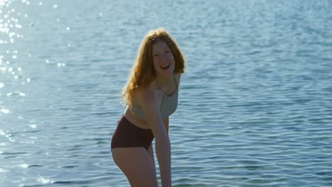 woman playing with water at beach 4k