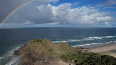 View-Of-Rainbow-Over-The-Ocean-In-Norries-Headland-In-NSW,-Australia---drone-shot