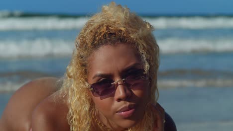 on a sun-kissed caribbean beach, a young hispanic girl in a bikini delights in the soothing embrace of the ocean waves facial close up