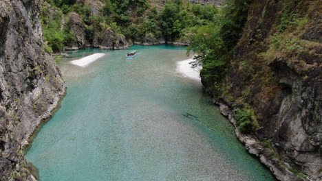 aerial shot over lake komani and in which a boat can be seen approaching the shore of the lake