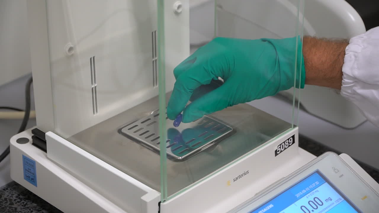 Handheld shot tablet pill on control scale, Pharma environment