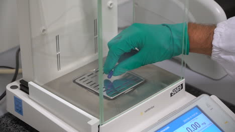 handheld shot tablet pill on control scale, pharma environment