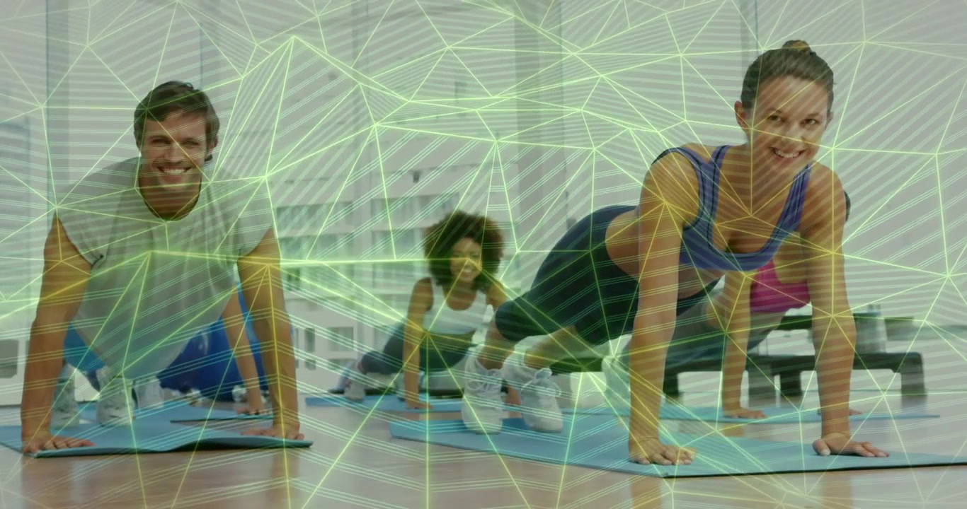 Instructor dando indicaciones a un grupo de fitness que realiza flexiones sobre colchonetas azules, ganando fuerza y resistencia.