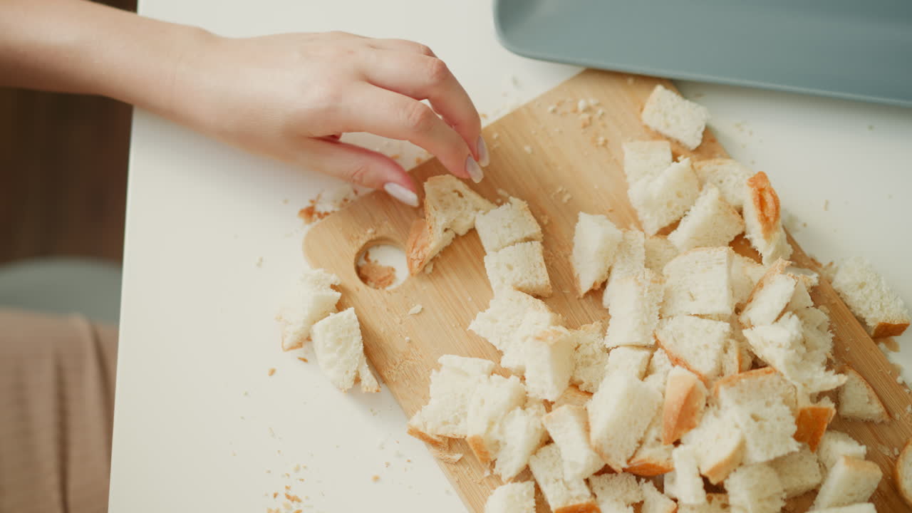 Woman cutting bread into croutons