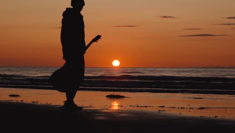 man running with guitar in back sand beach at sunset-7