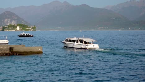 a small sightseeing boat on its way to its docking point in the port of stresa