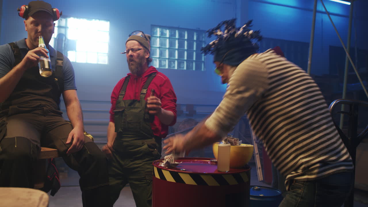 Men celebrating and having fun, throwing money and drinking beer in a workshop