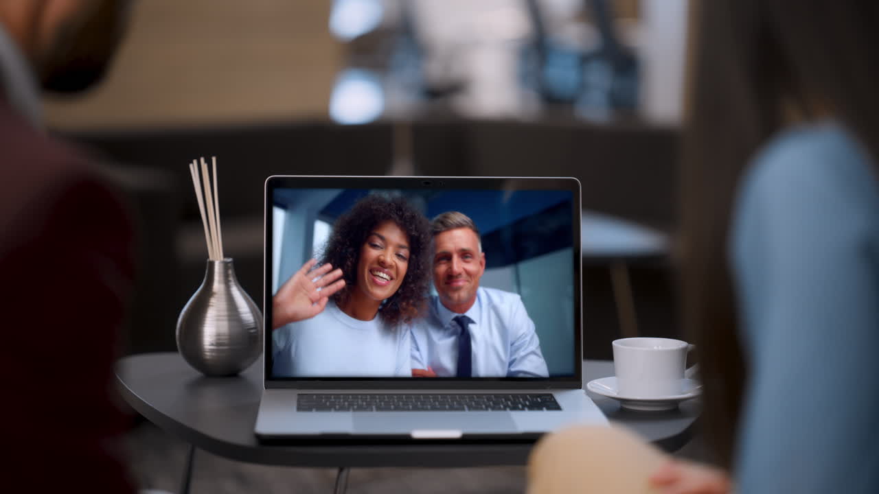 Business team talking videocall using laptop webcam in modern cafe close up