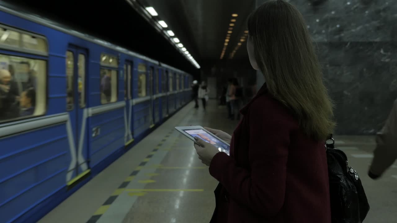 женщина использует планшет на станции метро