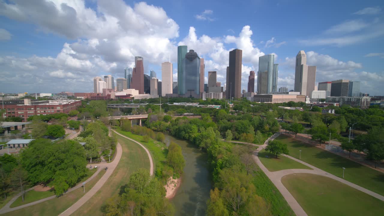Esta toma de dron de gran angular establece y captura el alcance completo del centro de Houston, Texas, mostrando el denso grupo de rascacielos contra un brillante cielo de Texas.