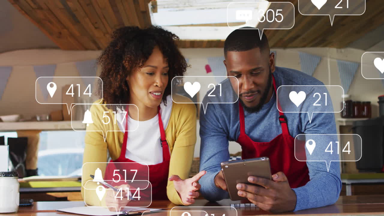 Social media engagement animation over two people in aprons using tablet
