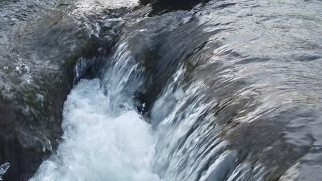 corriente de agua en una mini cascada con burbujas en un invierno frío