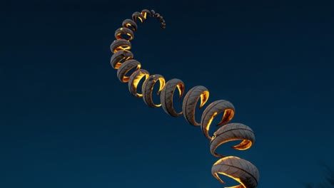 a captivating spiral structure illuminated against the night sky, showcasing its unique design and architectural elegance in a stunning visual composition
