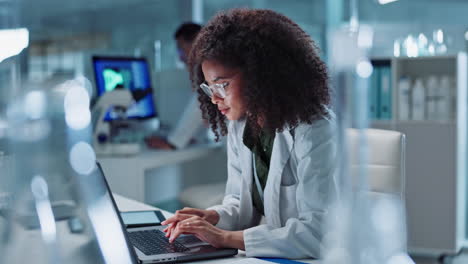 female scientist working on laptop in a laboratory