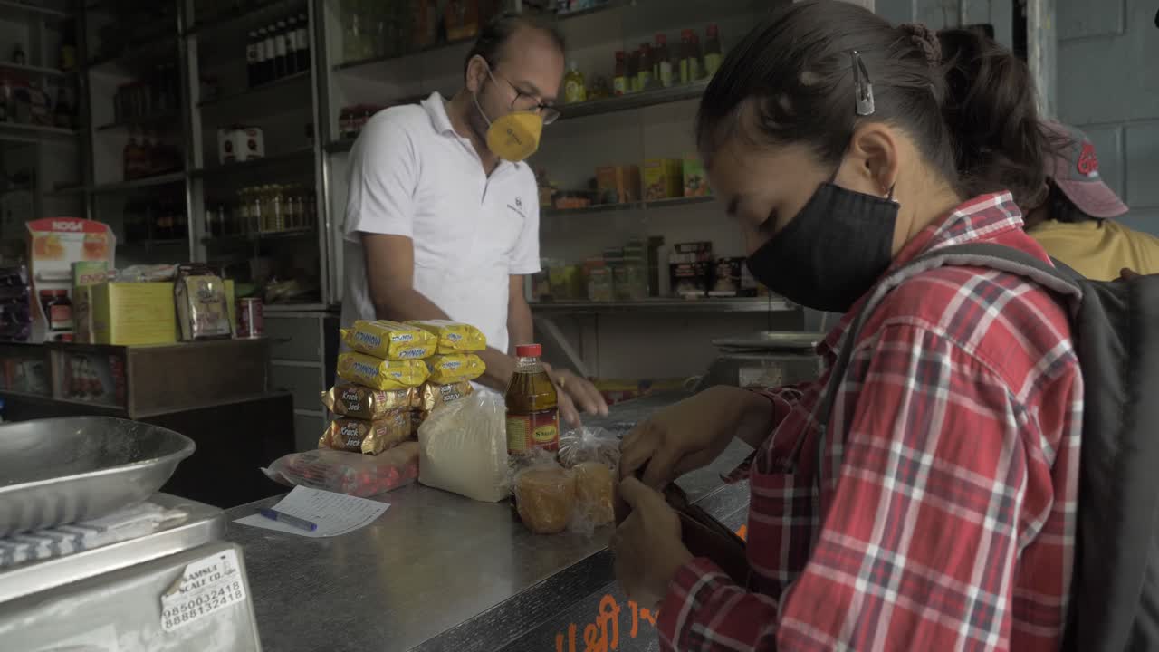 A young indian woman buying groceries at the local farmers market for stocking the essentials before curfew time in the second wave lockdown in India