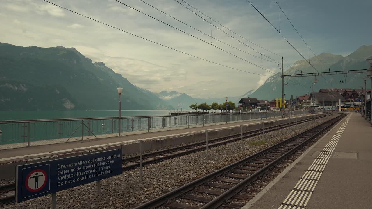 Static shot of a train station beside an alpine lake near Interlaken, Switzerland