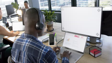 hombre de negocios afroamericano usando computadora con pantalla en blanco en la oficina, cámara lenta, espacio de copia