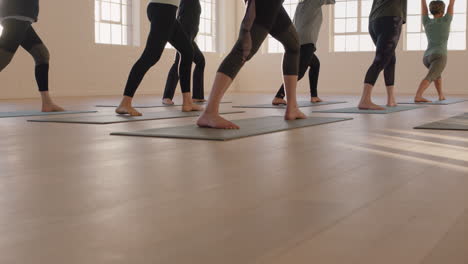 yoga-class-of-healthy-mature-women-practicing-warrior-pose-enjoying-morning-physical-fitness-exercise-workout-in-studio