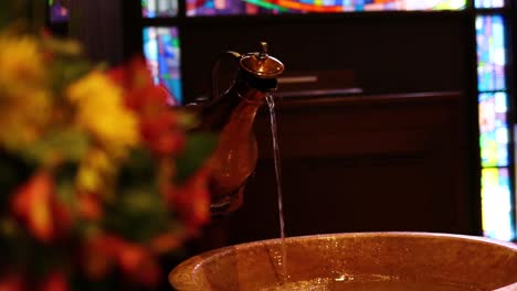 gorgeous rack focus of colorful church flowers and flowing water fountain