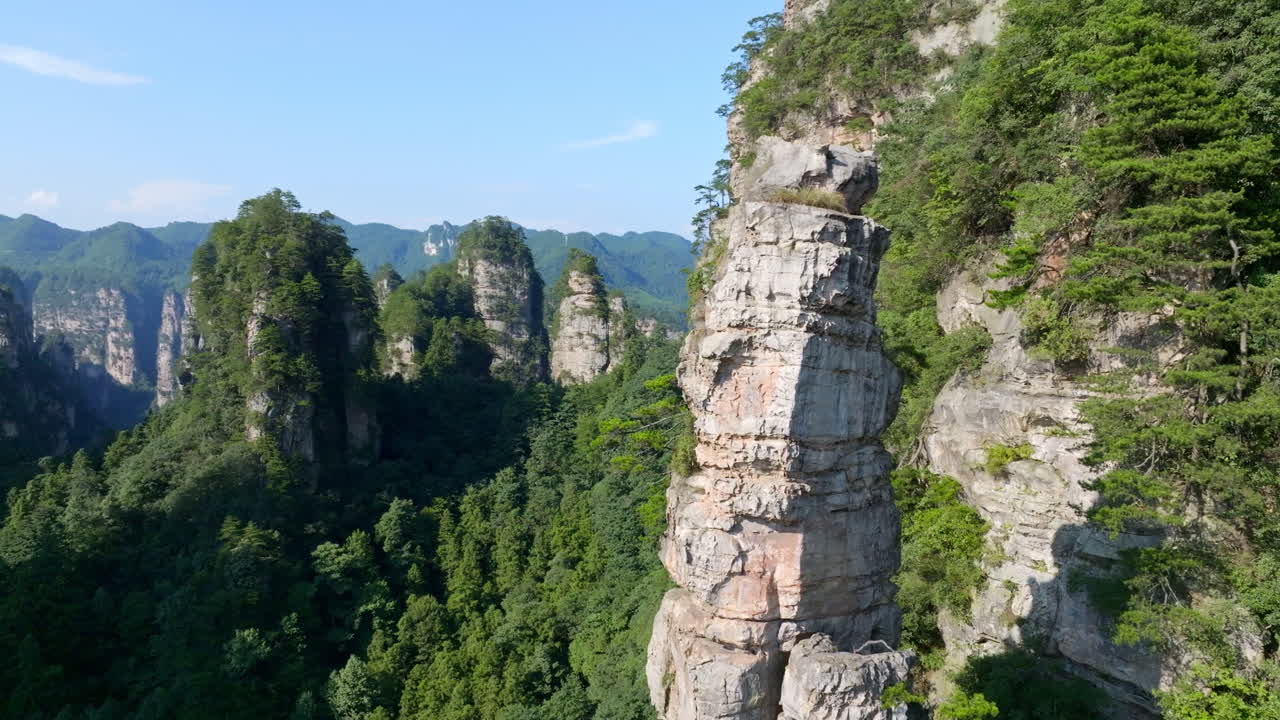 Aerial view circling a rocky karst mountain peak in Zhangjiajie park, China