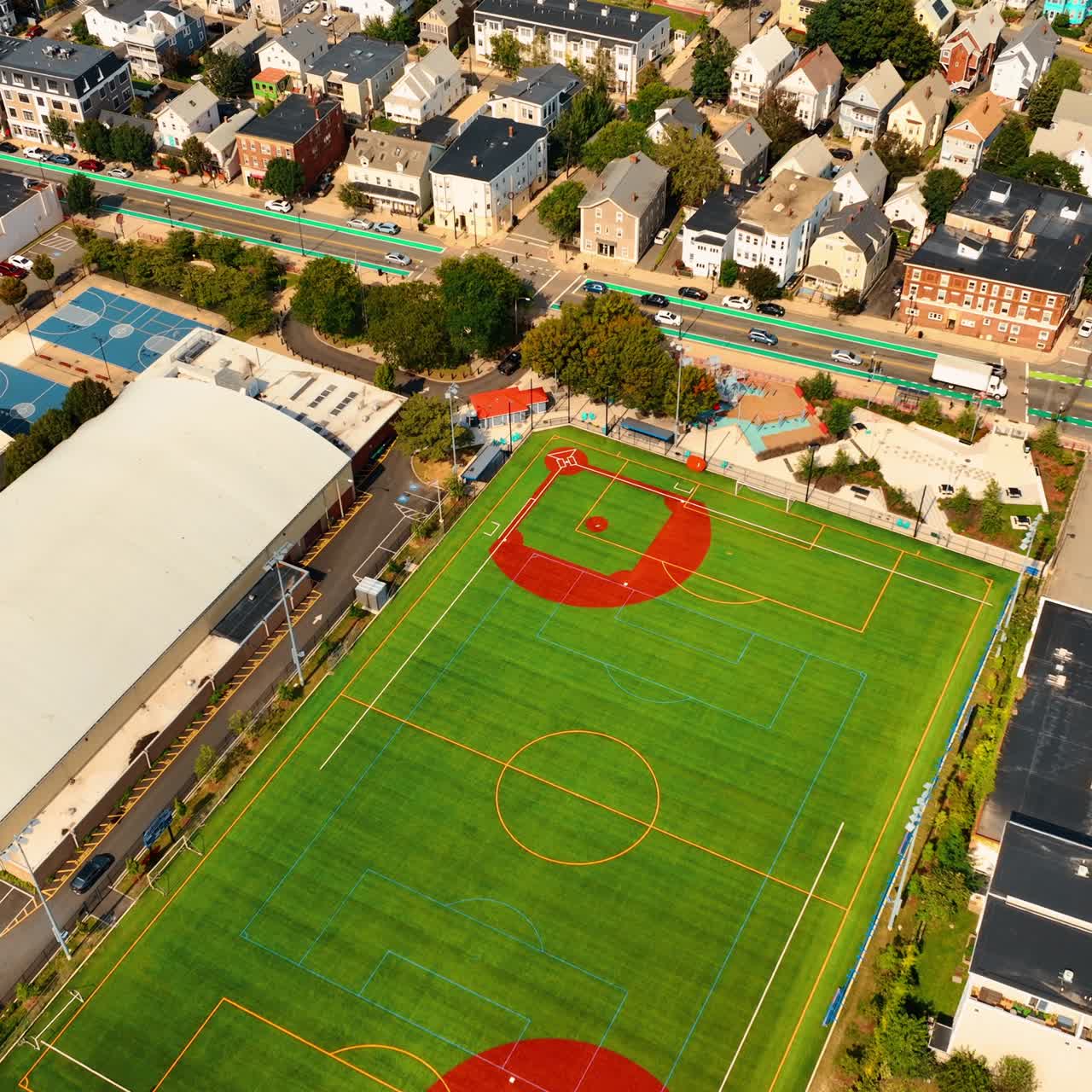 Udsigt over grøn fodboldbane i et byområde. Solrigt panorama af Cambridge, Massachusetts, USA, set fra toppen