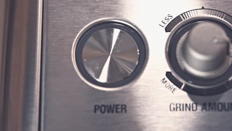 close-up of the buttons of a stainless steel expresso press machine for ground coffee