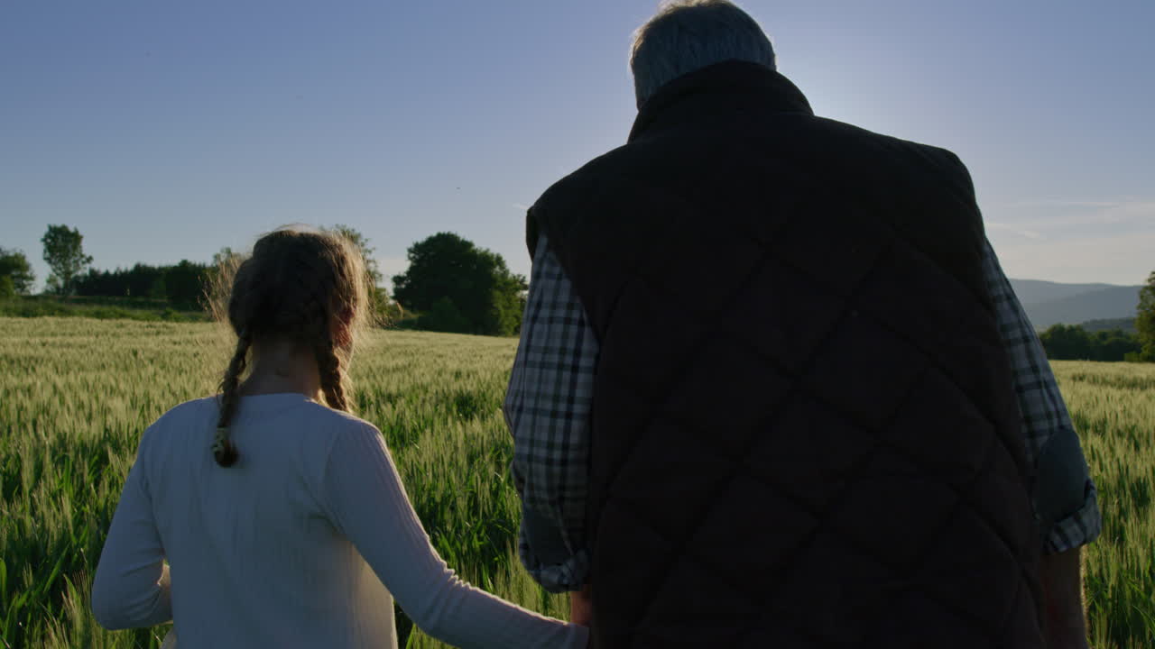 Grandfather and Granddaughter Walking in a Field