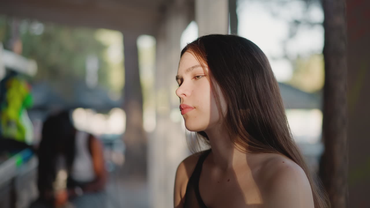 불안한 젊은 여성은 해변 바에서 클로즈업에 앉아 있습니다. 사려 깊은 갈색 여성은 술을 기다리고 클럽에서 혼자 시간을 보내고 있습니다. 리조트 레스토랑에서 젊은 피곤한 손님.